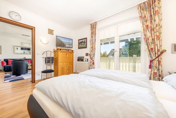 Schlafzimmer mit Blick zum Balkon und ins Wohnzimmer