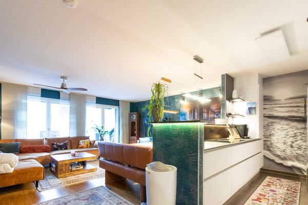 Blick in Wohnzimmer mit offener Küche