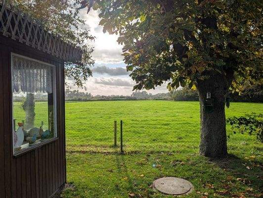 Blick über Wiesen und Felder vom Gartenhaus aus