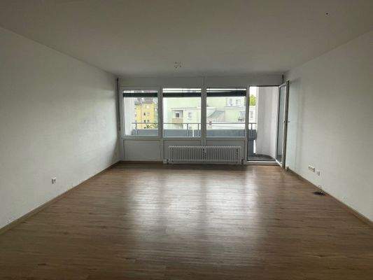 Wohnzimmer mit Essbereich und Zugang zum  Balkon 