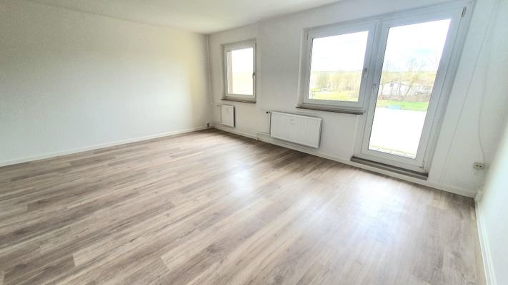 Wohnzimmer mit Tür zum großen Balkon