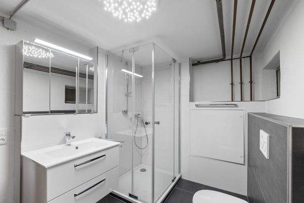 Modernes Duschbad mit Waschmaschinenanschluss im Untergeschoss