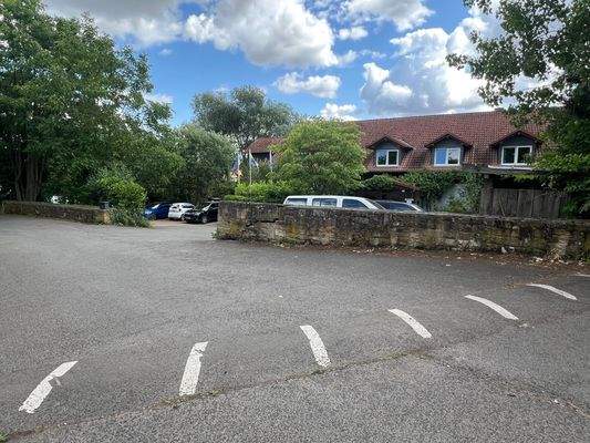 Hausansicht mit Parkplätzen