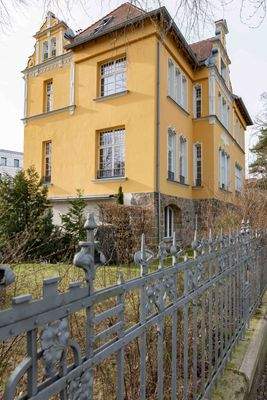 Hausansicht mit historischem Zaun