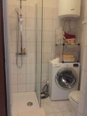 Badezimmer mit Dusche und Waschmaschines