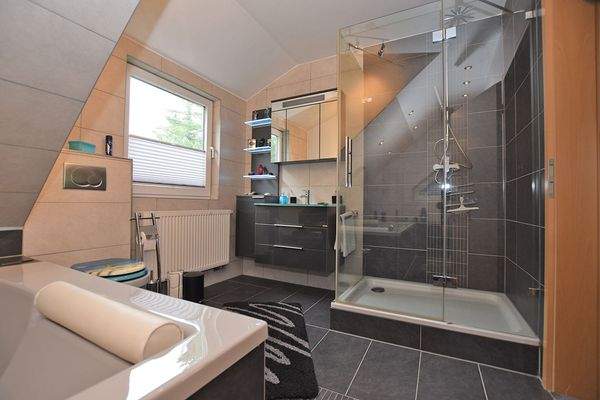 Ein großes Bad mit Wanne, Dusche, Waschtisch und WC ...