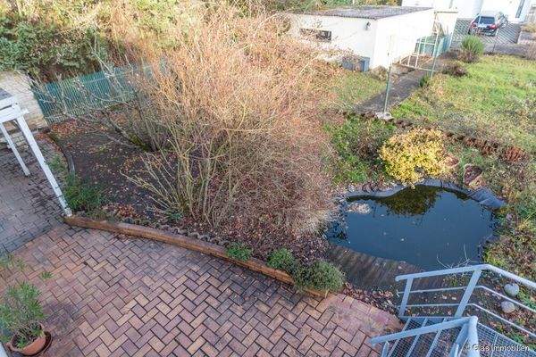 Blick in den Garten mit Teich und zweiter Garage