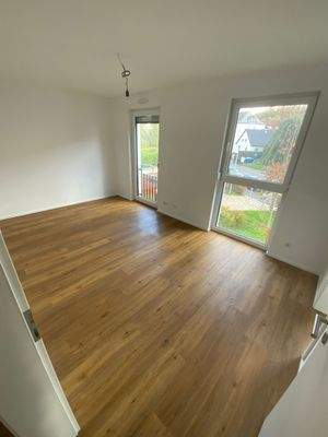 Schlafzimmer mit weißen Wänden und Vinylboden mit Holzoptik.JPG