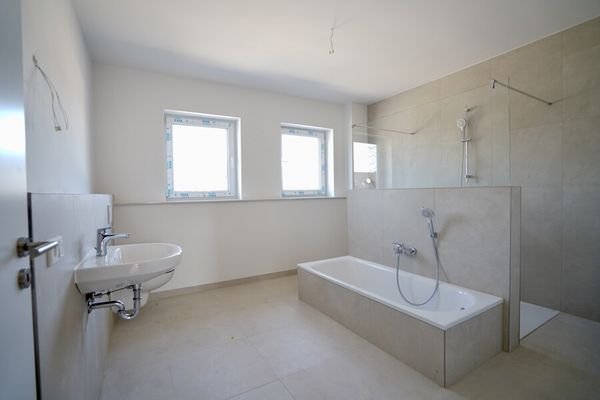 Badezimmer mit bodentiefer Walk-In-Dusche und Badewanne
