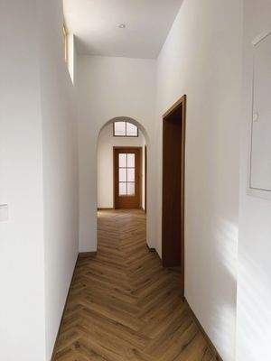 Langer Flur mit Holztür