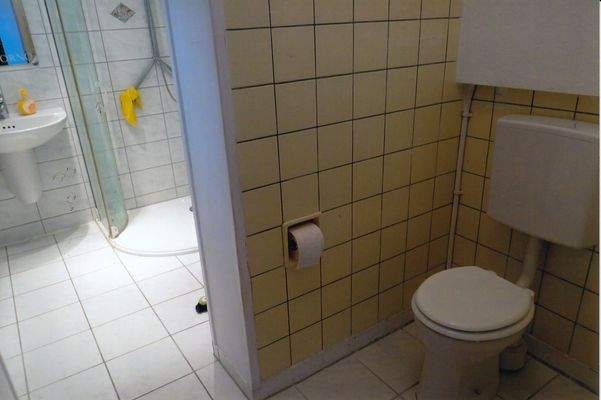 Toilette mit Blick ins Bad