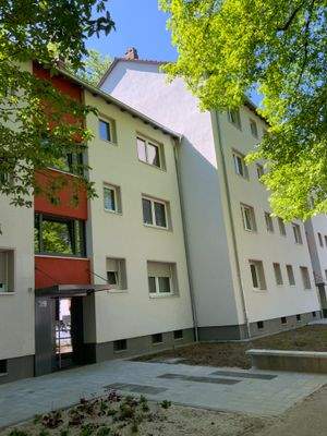 Vorderansicht Gebäude mit Hauseingang, Fenstern und Begrünung