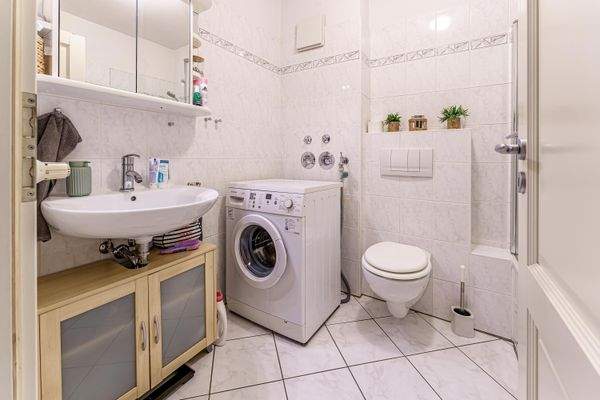 Badezimmer mit Waschmaschinenanschluss.