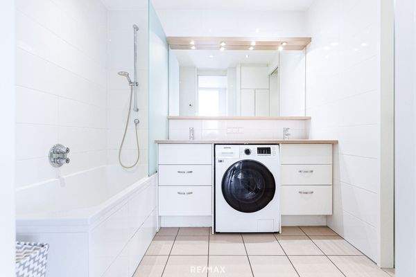 Badezimmer mit Badewanne und Waschmaschine