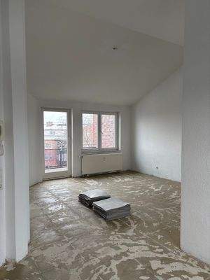 Wohnzimmer mit Zugang zum Balkon, zur Küche und zur zweiten Diele