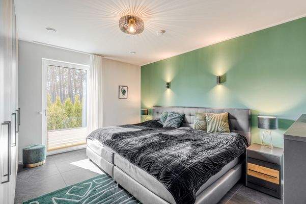 Ruhiges Schlafzimmer mit Blick ins Grüne und angenehmer Lichtführung