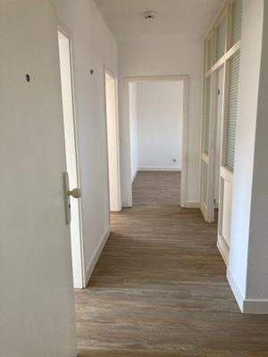 Geräumiger heller Flur, Boden PVC in Holzoptik, Wände rauhfaser weiß