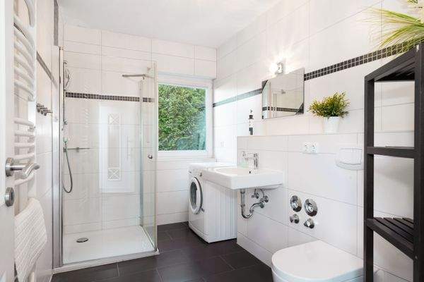 Das gepflegte Badezimmer mit Dusche und Waschmaschine