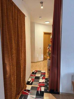 Flur mit Zugang zur Küche hinter dem Vorhang