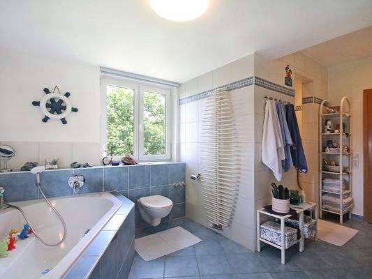 Viel Raum zur Entspannung im Tageslichtbadezimmer mit Eckbadewanne und Duschnische