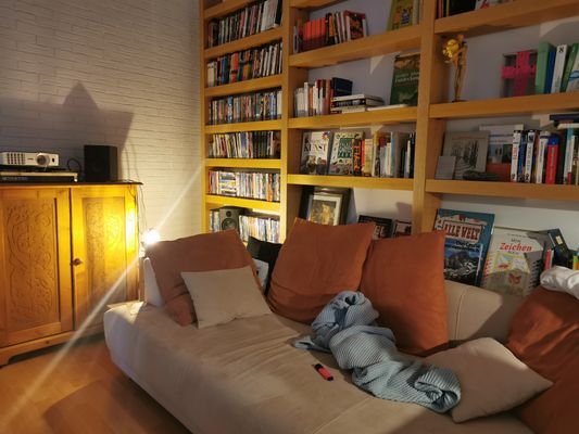 Wohnzimmer mit Hochregal und Kamin 