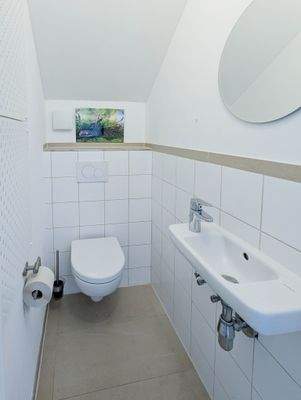 mit hell gefliestem Gäste-WC.