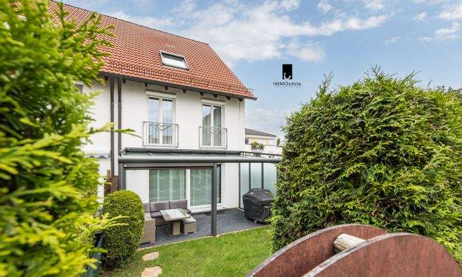 Blick auf das stilvolle Reihenendhaus mit gemütlicher Terrasse und eingewachsenen Garten