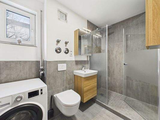 Badezimmer mit ebenerdiger Dusche und Waschmaschinenanschluss