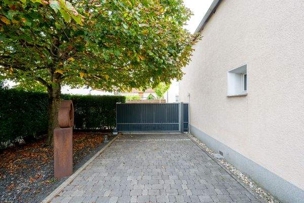 Grundstückszufahrt mit Schiebetor und Parkplätzen