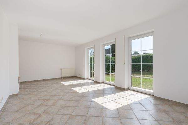 Der lichtdurchflutete Wohnbereich mit bodentiefen Fenstern