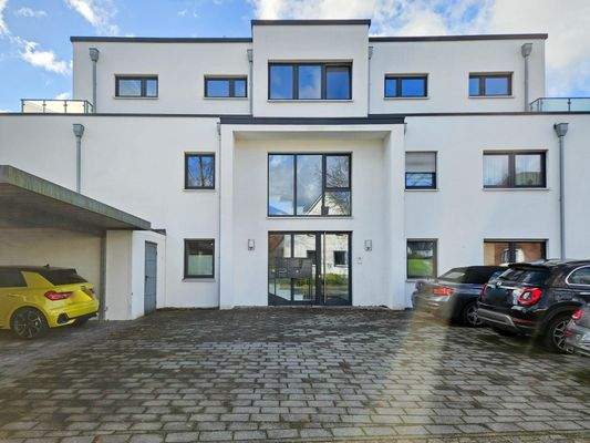 Hauseingang mit Stellplätzen