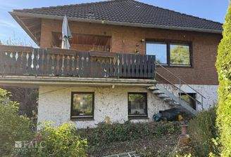 Blick vom Garten auf die teilüberdachte Balkonterrasse