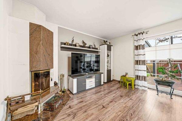 Wohnzimmer mit Kamin und Zugang zur überdachten Terrasse