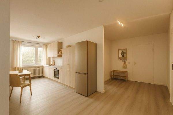 Offene Küche mit Zugang zum Balkon und Diele mit Einbauschränken