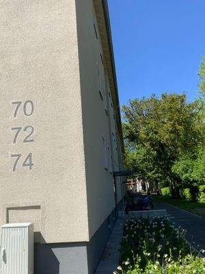 Außenansicht Seite mit Hausnummer, Fassade und Begrünung