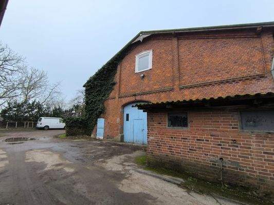 Am Haupthaus befindet sich seitlich der Eingang zur Tenne und den Stallungen