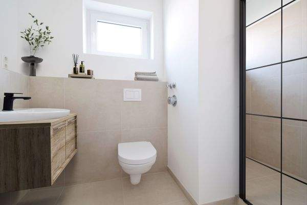 Badezimmer mit großzügiger Dusche und schwarzen Elementen