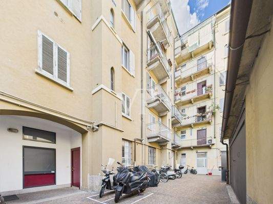 Cortile interno al palazzo con spazio moto e biciclette