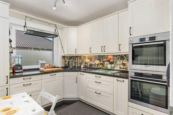 Küche (8,04m²) mit komplett ausgestatteter Einbauküche mit Markengeräten von Bosch und AEG.