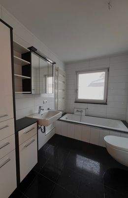 Modernes Badezimmer mit Wanne, Dusche und praktischen Stauraum-Lösungen