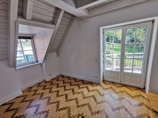 OG: Zimmer Kind 1 mit hellem Parkett und Zugang zum Balkon