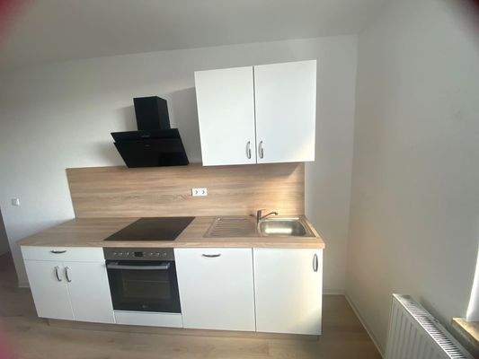 Küche mit Einbauküche inkl. Backofen und Spülmaschine; die Küche ist ausreichend groß für Tisch und Stühle