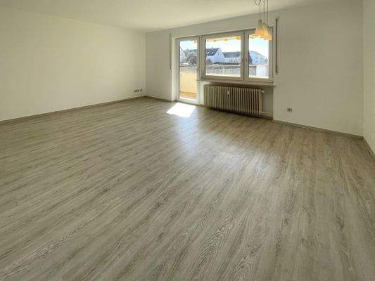 Großzügiges, einladendes Wohnzimmer mit Zugang zum Balkon