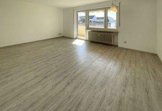 Großzügiges, einladendes Wohnzimmer mit Zugang zum Balkon