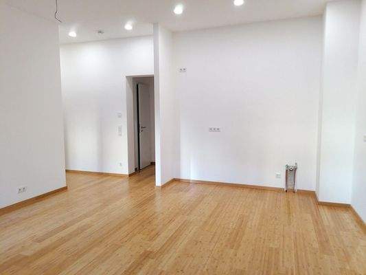 Wohnzimmer mit offener Küche und Fußbodenheizung