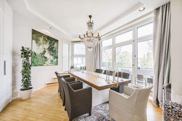 Heller, eleganter Essbereich mit Kristalllüster und umlaufenden Fensterfronten