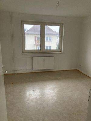 Schlafzimmer mit weiß angelegten Wänden und hellem Vinylboden