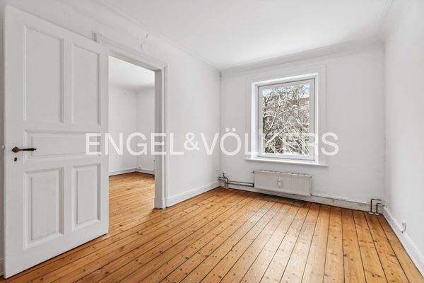 Heller Wohnraum mit hohen Decken, originalem Dielenboden und angenehmer Lichtstimmung.