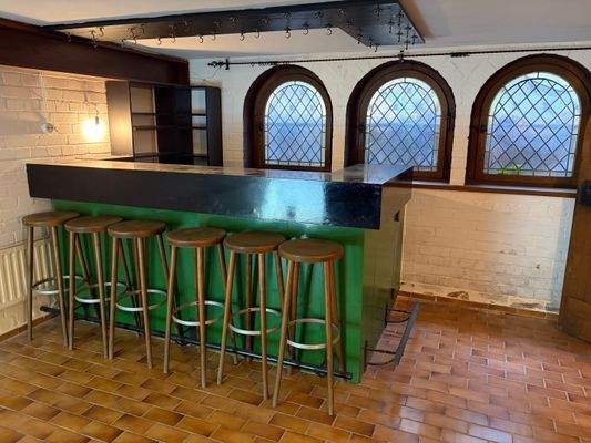 Bar mit Barhockern und Kamin