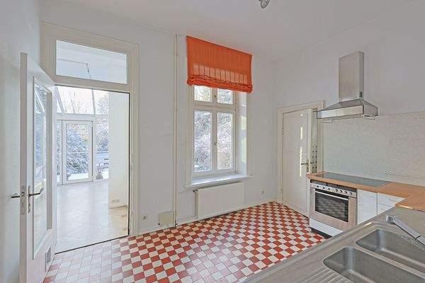 Gemütliche Küche mit rot-weißen Bodenfliesen und Gartenblick